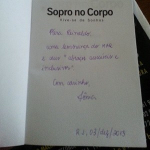 Foto da página de rosto do livro "Sopro no Corpo", com uma dedicatória a Reinaldo Ferraz feita pela esposa do MAQ