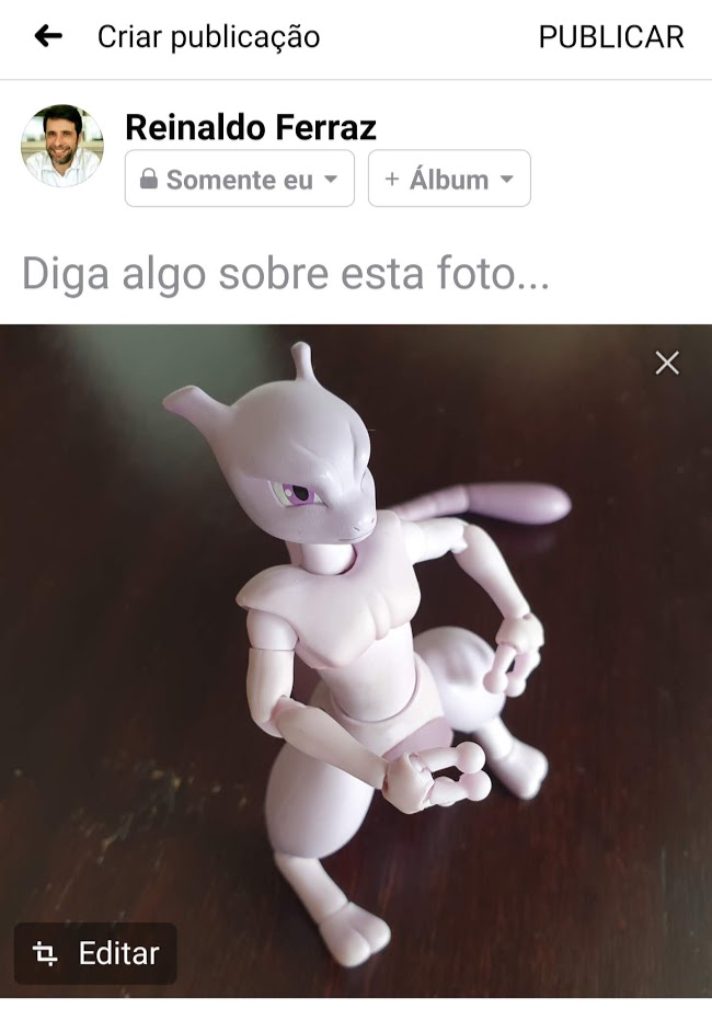 Captura de tela da interface do Facebook para publicação de imagem. Não há texto. Há apenas uma foto do boneco do pokemon Mewtwo.